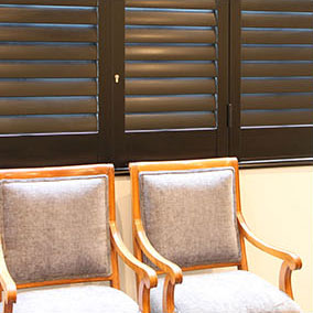 small chairs infront of large charcoal security window shutters